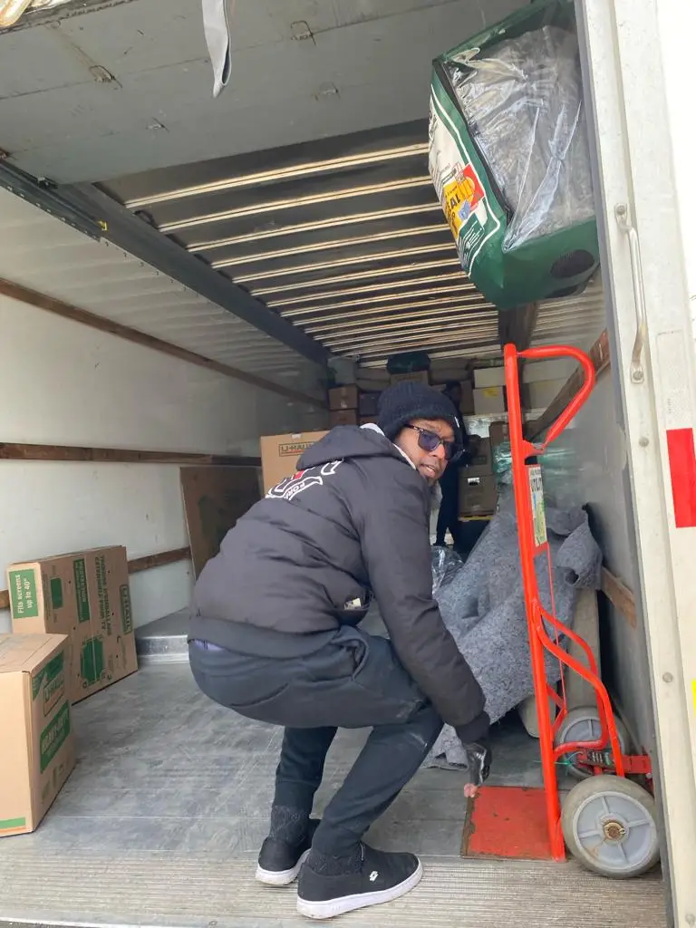 Local movers carefully handling furniture during a move in Windsor.